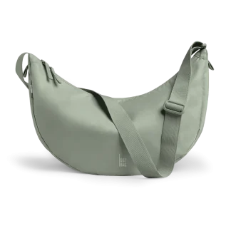 Light green crescent-shaped crossbody bag with adjustable strap and zip closures, 'GOT BAG' logo on front edge.